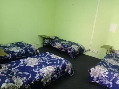 drie bedden in een kamer met blauwe en witte lakens bij Om Kedareshwar Boys Hostel in Kathmandu