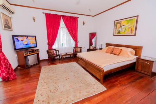 a bedroom with a bed and a flat screen tv at The Norfolk Heritage Airport Villa in Katunayaka