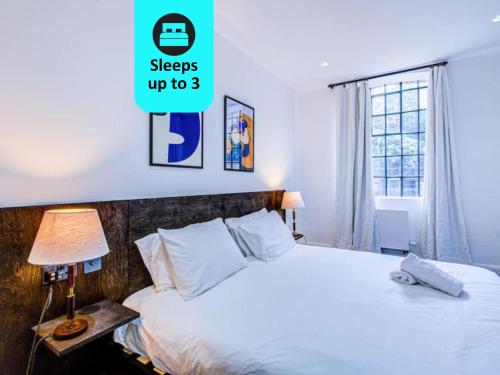 um quarto com uma cama e uma janela em Popular 1BR Apartment Close to Queens Park TUBE with SUPER FAST INTERNET em Londres