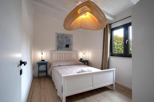 a bedroom with a white bed and a chandelier at Garden House Rovinj in Rovinj