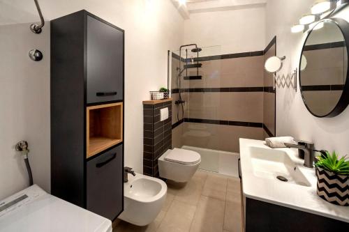 a bathroom with a sink and a toilet and a mirror at Garden House Rovinj in Rovinj