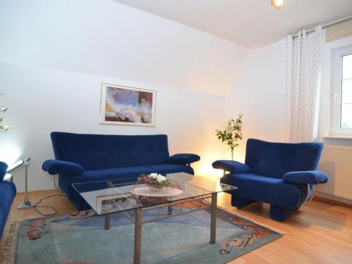 salon z 2 niebieskimi kanapami i stołem w obiekcie Apartment near ski area in Wehrstapel in Sauerland w mieście Meschede