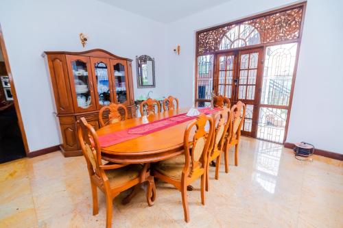 Un comedor con mesa y sillas de madera. en The Norfolk Heritage Airport Villa, en Katunayake