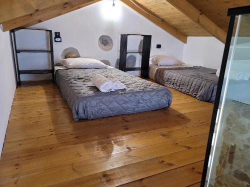 two beds in a room with a wooden floor at Fontana Leone in Spílion