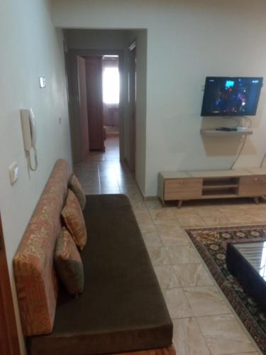 a living room with a couch and a flat screen tv at Paradise Days in Sfax