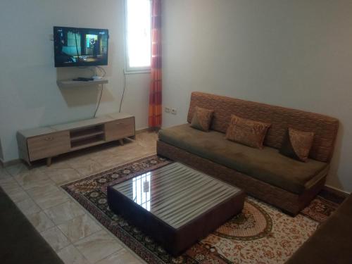 a living room with a couch and a tv at Paradise Days in Sfax