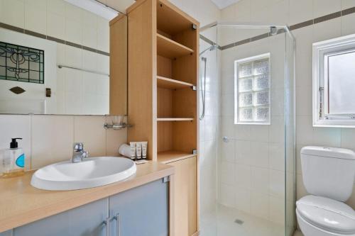a bathroom with a sink and a shower and a toilet at Relaxed Clovelly Beach Home - Parking - Cloey6 in Sydney