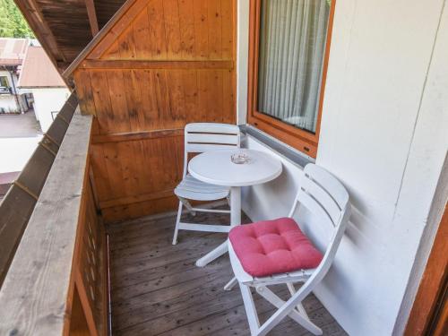un piccolo balcone con tavolo e 2 sedie di Pleasant Apartment in Ruhpolding with Swimming Pool a Ruhpolding