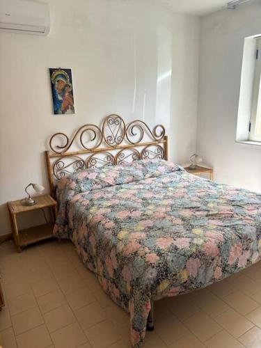 a bedroom with a bed with a quilt on it at Villetta con Giardino in Salerno