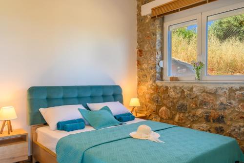 um quarto com uma cama azul com um chapéu em Althea Villa by breathtaking view em Agios Nikolaos