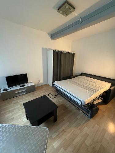 Habitación con cama y TV. en F1 centre ville sur cour en Champagnole