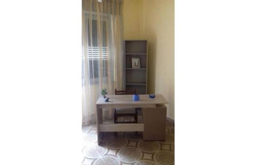 uma sala de estar com uma mesa e uma prateleira em NICE APARTMENT VERy MODERN em Caltanissetta