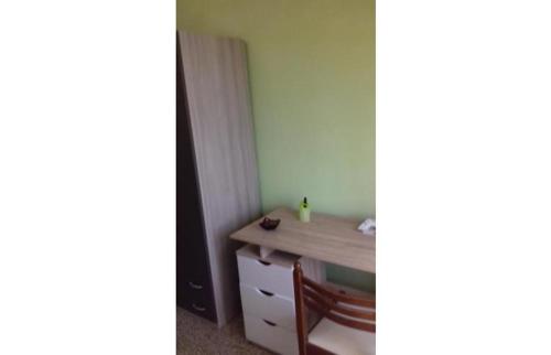 カルタニッセッタにあるNICE APARTMENT VERy MODERNのデスク、テーブル、椅子が備わる客室です。