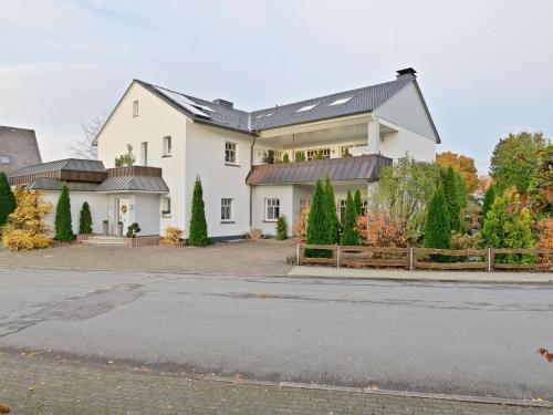 a large white house with a black roof at Spacious Apartment in Madfeld with Private Terrace in Madfeld