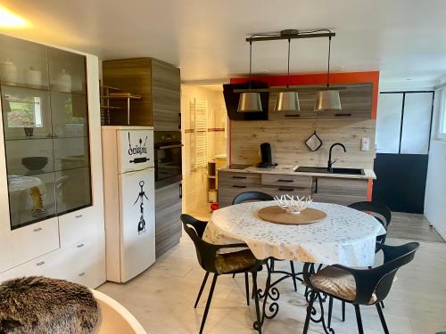 une cuisine avec une table et des chaises dans une cuisine dans l'établissement Le Gîte de Brigitte !, à Saint-Dié-des-Vosges