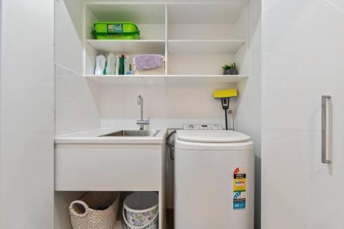 a small kitchen with a sink and a refrigerator at Joan's Beach Cottage in Mount Martha