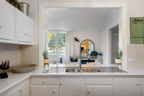 a white kitchen with a sink and a counter at Janie's Cottage - Secluded Wine Country Home in Broke