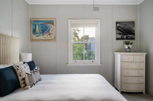 a bedroom with a white bed and a window at Janie's Cottage - Secluded Wine Country Home in Broke