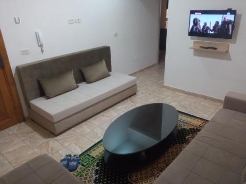 uma sala de estar com um sofá e uma mesa em Lovely Paradise em Sfax