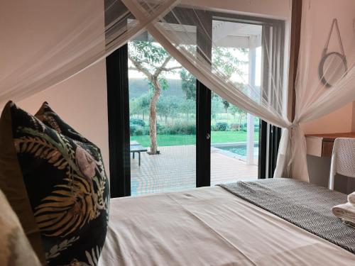 a bedroom with a bed and a large window at Lucky Crane Villas in McGregor