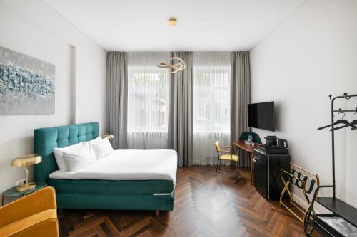 um quarto de hotel com uma cama e um sofá azul em St Casimir Apartments em Vilnius