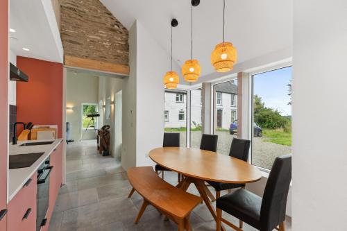 a kitchen and dining room with a wooden table and chairs at Luxury Stargazers Barn; Close to Coast, Town and Trails in Pembrokeshire