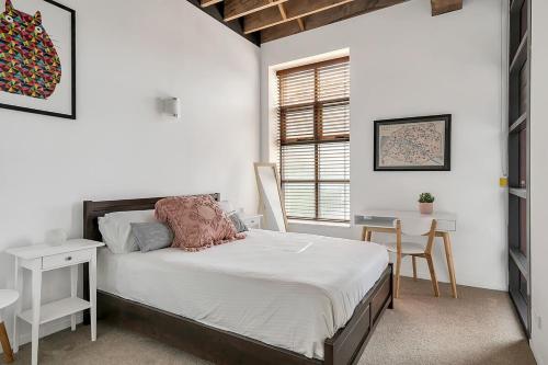 1 dormitorio con cama, escritorio y ventana en STYLISH APARTMENT IN CHIPPENDALE //PRIVATE PARKING, en Sídney