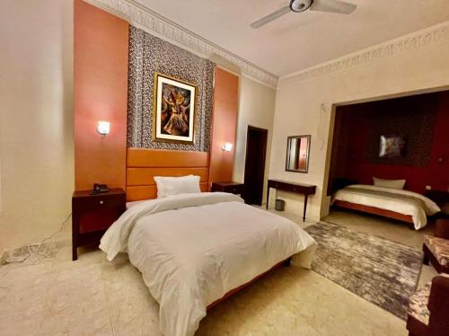 a bedroom with a large bed and two beds sidx sidx sidx at Shelton Hotel Mardan in Mardan