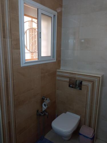 a bathroom with a toilet and a window at Lovely Paradise in Sfax