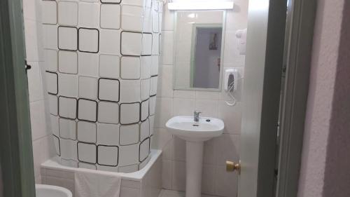 a white bathroom with a sink and a mirror at Casadidoru in Mansilla de las Mulas