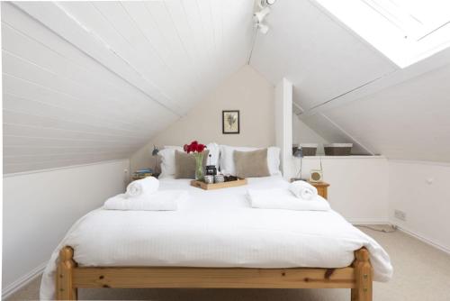 a white bedroom with a bed in a attic at Rutherglen in Porthallow