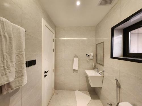a white bathroom with a sink and a toilet at Olaya Residence in Riyadh