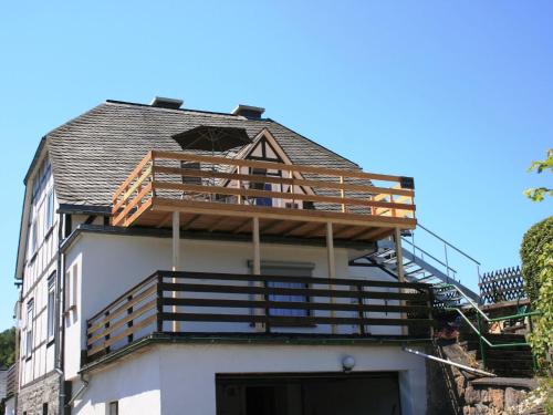 a house with a balcony on the top of it at Modern apartment near Willingen with private terrace and use of garden in Willingen
