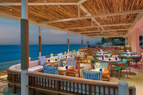 a restaurant with tables and chairs and the ocean at The Westin St Thomas Beach Resort & Spa in Frydendal