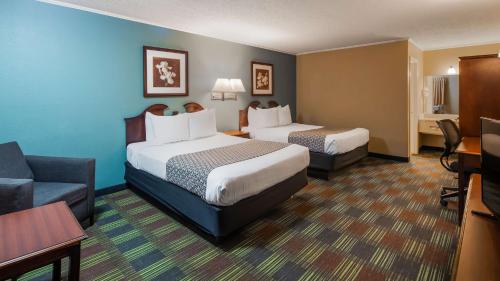 a hotel room with two beds and a couch at SureStay by Best Western Cameron in Cameron