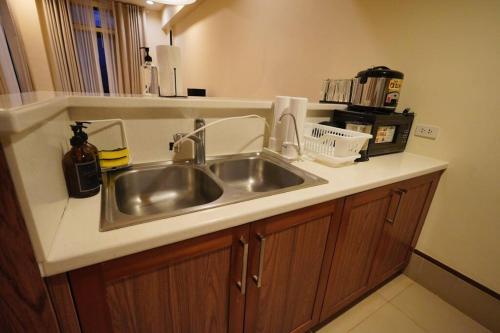 a kitchen counter with a stainless steel sink at 2BR Penthouse in Anvaya Cove in Morong
