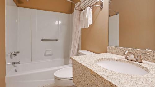 a bathroom with a sink and a toilet and a tub at SureStay by Best Western Cameron in Cameron