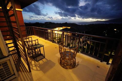 a balcony with two chairs on top of a building at 2BR Penthouse in Anvaya Cove in Morong