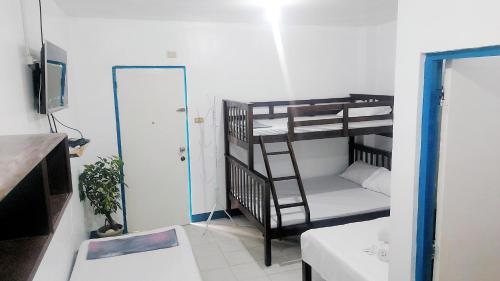 Zimmer mit 2 Etagenbetten und einem TV in der Unterkunft Galera Pension House in Balatero