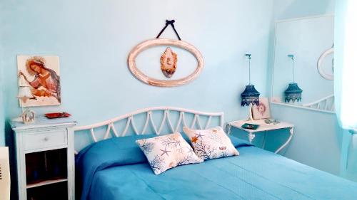a blue bedroom with a bed and a mirror at One bedroom house with shared pool and furnished garden at Lentia 2 km away from the beach in Vulcano