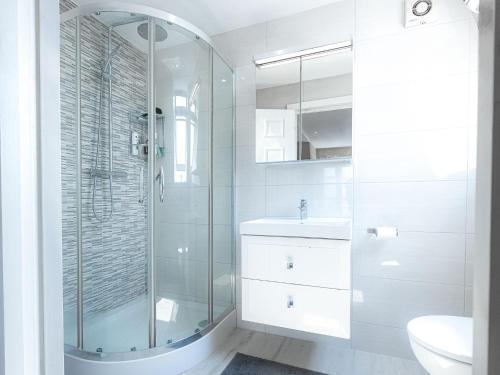 a bathroom with a glass shower and a sink at Family-Friendly 3-Bedroom Sojo Stay in London in London