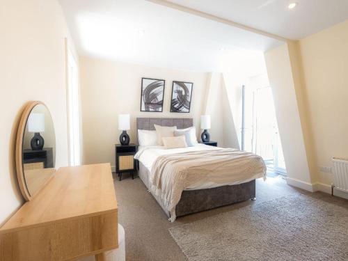 a bedroom with a bed with a mirror and a table at Family-Friendly 3-Bedroom Sojo Stay in London in London