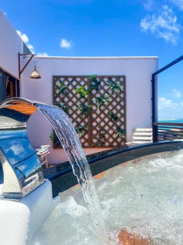 a water fountain in a pool in a house at Casa Macao Pipa in Pipa