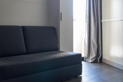 a blue couch in a living room with a window at Noba Hotel e Residenze in Rome
