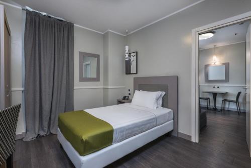 a bedroom with a bed and a desk and a television at Noba Hotel e Residenze in Rome