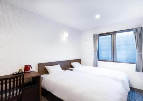 a hotel room with two beds and a window at HOTEL DORIA in Kyoto