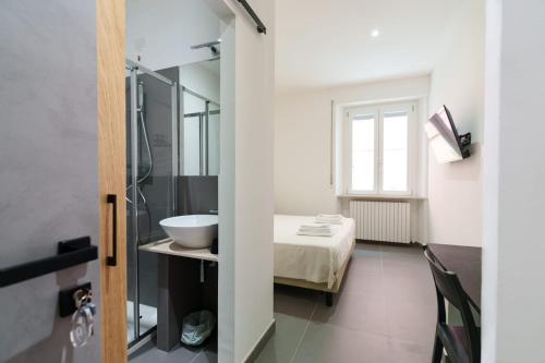 y baño con cama, lavabo y espejo. en Camere Cavour, en Macerata