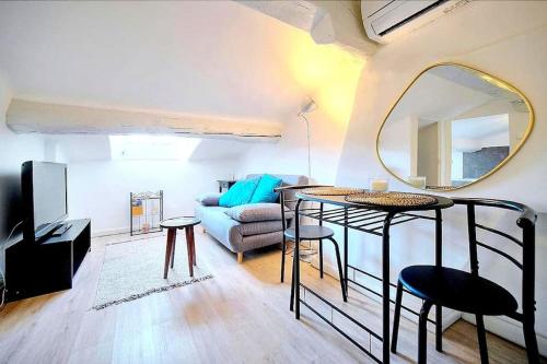 uma sala de estar com um sofá e um espelho em Palais des festivals et rue d'Antibes charme mansardes em Cannes