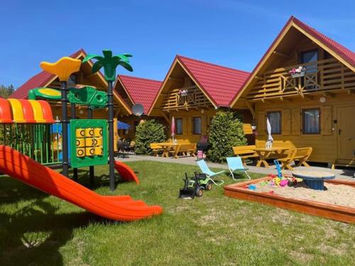 a house with a playground with a slide at Złoty Brzeg Wicie in Wicie
