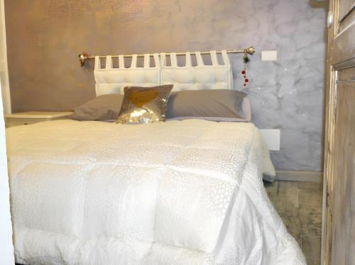 uma cama branca com um edredão branco e almofadas em One bedroom house with wifi at Vittoria em Vittoria